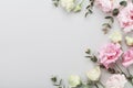 Floral border of beautiful flowers and green eucalyptus leaves on gray table top view. Flat lay composition.