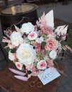 Floral bunch in round box. Bouquet in peach color of beautiful preserved flowers. White rose , mixed roses flowers, dried palm