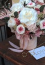 Floral bunch in round box. Bouquet in peach color of beautiful preserved flowers. White rose , mixed roses flowers, dried palm