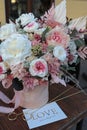 Floral bunch in round box. Bouquet in peach color of beautiful preserved flowers. White rose , mixed roses flowers, dried palm