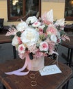 Floral bunch in round box. Bouquet in peach color of beautiful preserved flowers. White rose , mixed roses flowers, dried palm