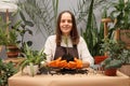 Floral business entrepreneur. Gardening and botany hobby. Florist working with plants. Smiling young woman botanist wearing apron Royalty Free Stock Photo