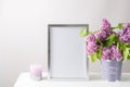 Floral card or poster mockup or silver photo frame in modern style with lilac plant flowers in bucket vase on white table cloth Royalty Free Stock Photo