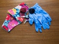 Floral Cloth Mask, Keys, Sunglasses, and Disposable Blue Gloves on Wood Table