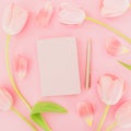 Floral composition of tulips flowers with notebook and pen on pink background. Flat lay, top view. Spring time background Royalty Free Stock Photo