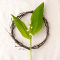 Floral composition. Wreath made of roools, leaves, and flowers lily of the valley on tissue white background. Rustic style of home