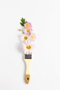 Floral creative concept. paintbrush and lilac paint. fresh chrysanthemum flowers on white background. flat lay, vertical frame, Royalty Free Stock Photo