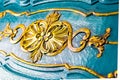 Floral details on a wooden chest, antique style. Close up of yellow carvings on beautifully sculpted blue furniture background
