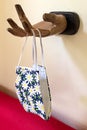 Floral face mask hangs on a hook