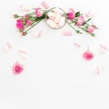 Floral feminine composition with pink roses and marshmallow on white background. Top view. Flat lay