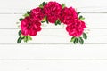 Floral frame composition of red peonies flowers and leaves on white rustic background. Flat lay Royalty Free Stock Photo