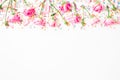 Floral frame made of pink flowers and bright candy confetti on white background. Flat lay, Top view. Roses flower texture Royalty Free Stock Photo