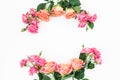 Floral frame made of rink and orange roses, buds and green leaves on white background. Flat lay, top view. Spring background Royalty Free Stock Photo