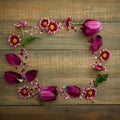Floral frame of pink flowers on wood background. Flat lay, Top view.