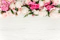 Floral frame wreath made of pink and beige peonies flower buds, eucalyptus branches and leaves isolated on white wooden Royalty Free Stock Photo