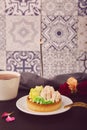 Floral french birthday tart with flowers and coffee. Ceramic tile background. Pink floral cake, guilty pleasure. Hygge