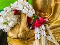 Floral garland on hands of Buddha statue Royalty Free Stock Photo