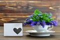 Floral greeting card with muscari flowers in vintage cup on wooden background Royalty Free Stock Photo