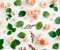 Floral pattern made of pink and beige roses, green leaves, branches on white background. Flat lay, top view. Valentine\'s Royalty Free Stock Photo