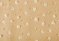 Floral pattern made of white spring flowers on brown paper background. Flat lay. Royalty Free Stock Photo