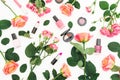 Floral pattern with roses, buds, green leaves and feminine cosmetics on white background. Flat lay, top view. Spring background Royalty Free Stock Photo