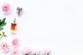 Floral perfume for women. Bottle of perfume near delicate pink flowers on white background top view space for text