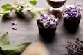 Floral purple cupcakes using trend Dreamy Escapism. Desserts and flowers background. Aesthetics food