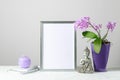 Floral spring card or poster mockup or silver photo frame with pink orchid flowers in the purple pot,  decorative Buddha statuette Royalty Free Stock Photo