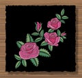 Floral stitched ornament with stitch flowers and sprigs. Embroidery roses and leaves on a dark flap cloth