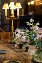 Floral decoration on oak table. High society period fine dining