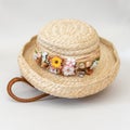 Floral trimmed Spring straw hat sitting on top of handmade woven basket