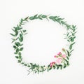 Floral wreath frame made of pink roses and eucalyptus branches on white background. Flat lay, top view Royalty Free Stock Photo