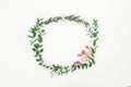 Floral wreath frame of pink roses flowers and eucalyptus branches on white background. Flat lay, top view Royalty Free Stock Photo