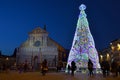 Florence, December 2018: Illuminated Christmas Tree in Piazza Santa Maria Novella with the Basilica on background