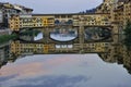 The Ponte Vecchio reflects onto the Arno river in Florence , Italy