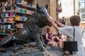 Florence ITALY - August 6, 2023 - Woman with her hands on the boar's snout at Fontana del Porcellino for good luck