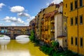 Florence Italy Houses Ponte Vecchio Bridge along Arno River Under bright Blue Sky Royalty Free Stock Photo