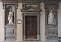 Florence, Italy - 2020, January 18: Old wooden entry door to the Uffizi Gallery Museum. Cosimo and Lorenzo Medici marble statues Royalty Free Stock Photo