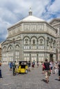 Florence, Italy - 25 June 2018: Rickshaw at Baptistery (Battistero di San Giovanni, Baptistery of Saint John) on Piazza San