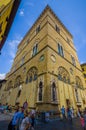 FLORENCE, ITALY - JUNE 12, 2015: Unidentified people walking outside of an historic church, Saints images on the corners