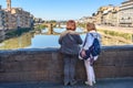 Tourists look at St.Trinity Bridge from Ponte Vecchio Bridge over river Arno at sunny day in Florence. Italy Royalty Free Stock Photo