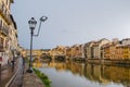 Florence, Italy - Side view of the view of the Ponte Vecchio and the Arno river reflecting the buildings in its water during a