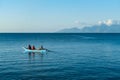 Flores/Indonesia 20290808: A fishermen`s boat crossing a calm sea near Maumere, Indonesia There are three men in one small, blue