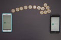 Florianopolis, Brazil. 07/10/2020: Arrow made by 1 Real coins showing the transfer of money from one smartphone to another.