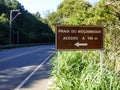 Sign by the road reading `Mocambique beach, access in 100 meters`. Mocambique is the longest beach in the island of Florianopolis Royalty Free Stock Photo