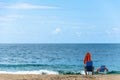 Chair, umbrella and person on the beach.