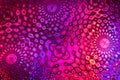 Florid pink-violet pattern on textured holographic paper. Selective focus.