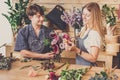 Florist and assistant in flower shop delivery make rose bouquet