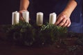 Woman attaches candle holder on a Christmas wreath