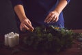 Woman attaches candle holder on a Christmas wreath